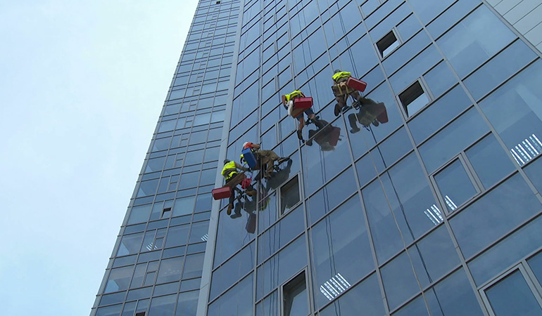 Cordiste nettoyant la façade d'un immeuble sur Paris